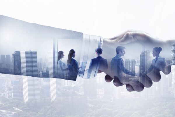 Double exposure image of business handshake and modern cityscape